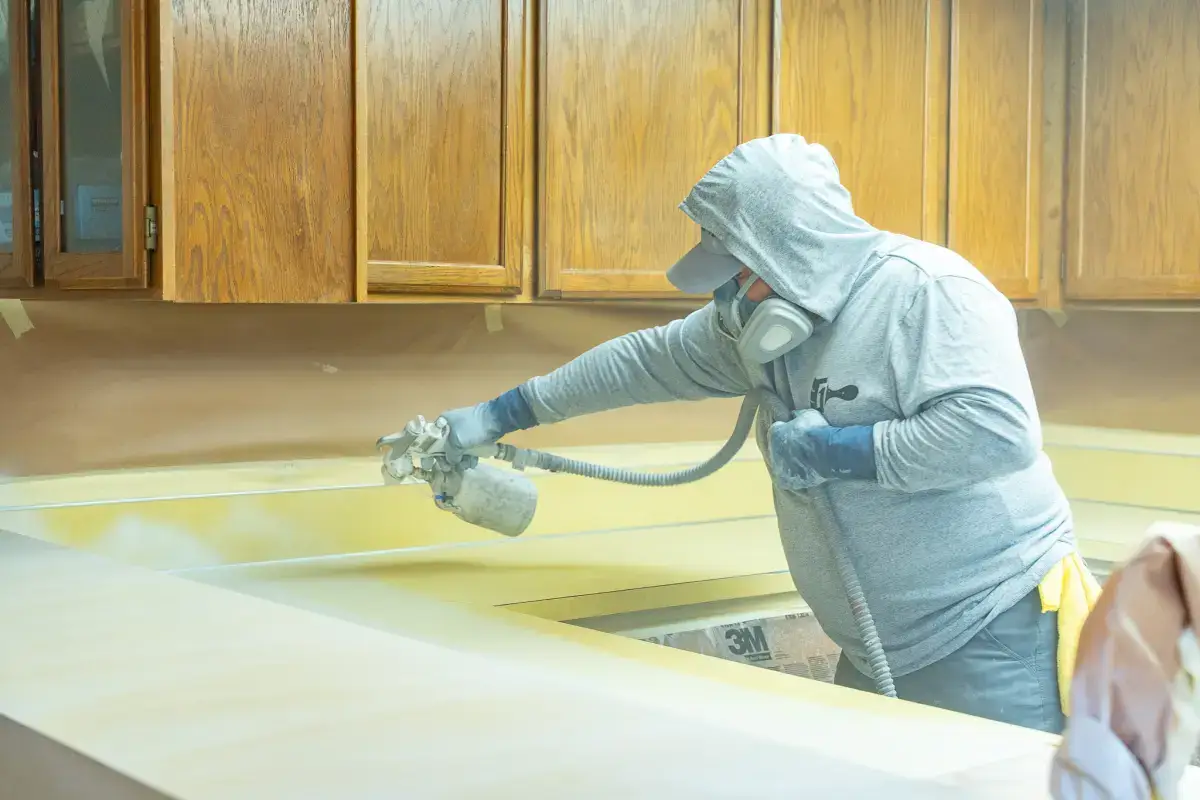 Grit Co owner spraying a kitchen countertop with a refinishing gun